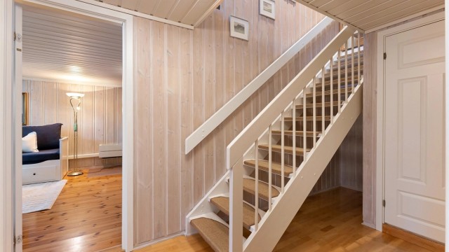 Fra gangen er det adkomst til stue, soverom, vaskerom og boder. Trappen i tre leder opp til første etasje.