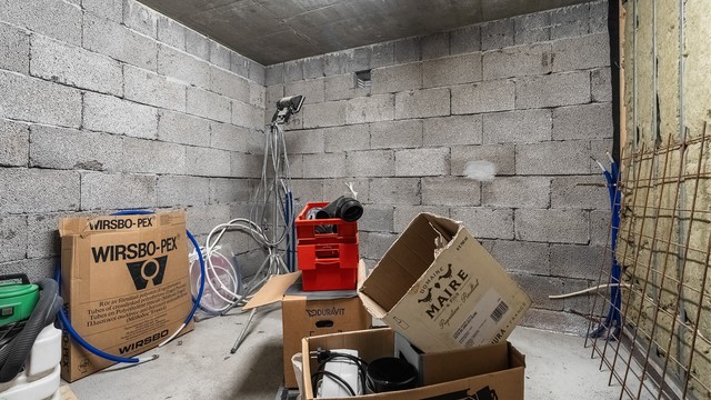 Kjellerrom med vegger av lettklinkerblokker og støpt betonggulv.