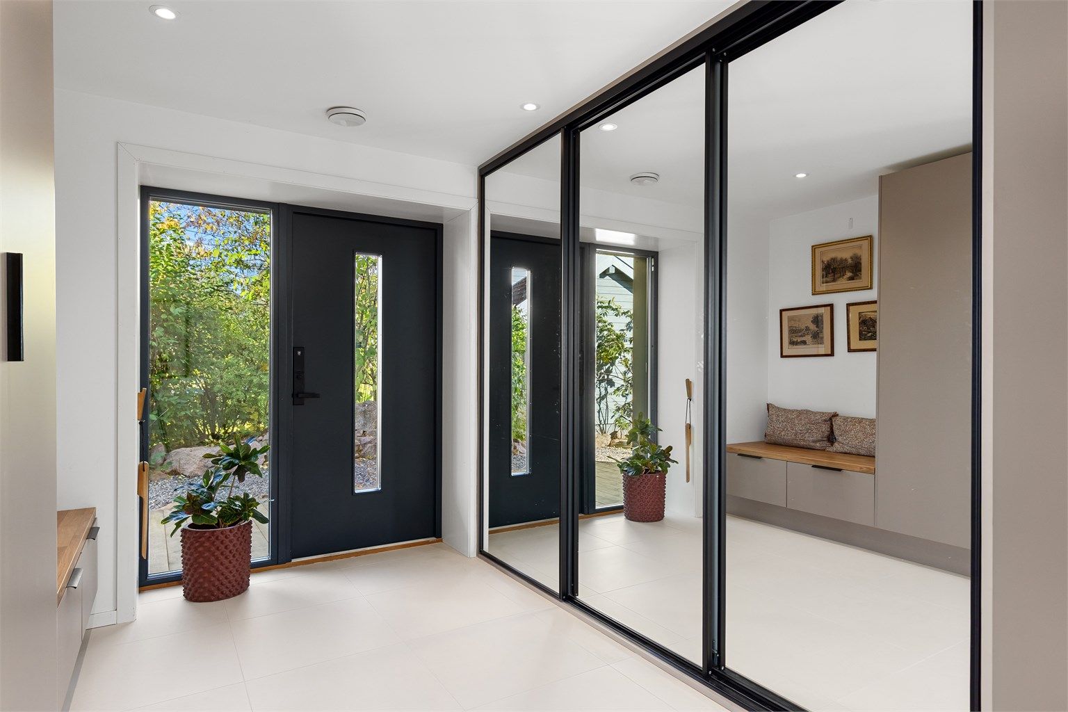 Entréen har flislagt gulv med behagelig gulvvarme og stor skyvedørsgarderobe med speilfronter.