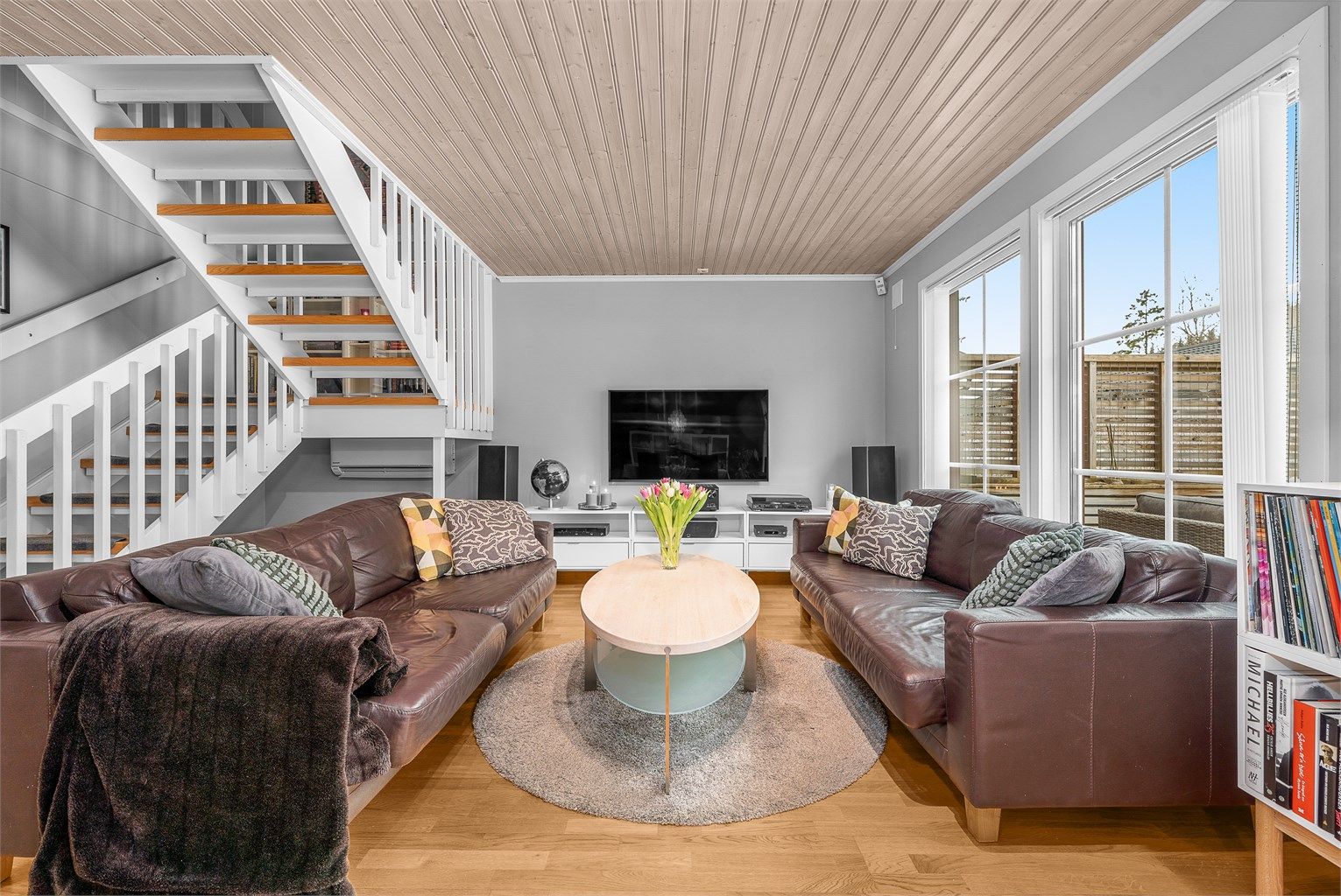 Store vinduer slipper inn rikelig med dagslys og gir utsyn mot hagen.