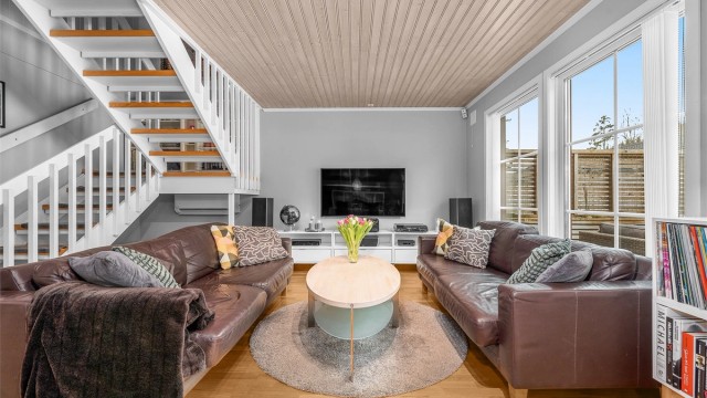 Store vinduer slipper inn rikelig med dagslys og gir utsyn mot hagen.