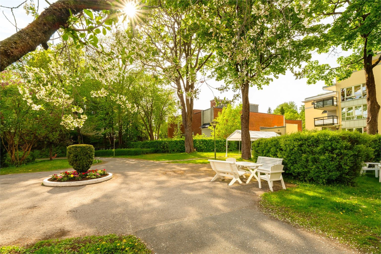 Bakgården er pent opparbeidet med sittebenker, sykkelparkering, plenarealer, trær, prydbusker og diverse beplantning.