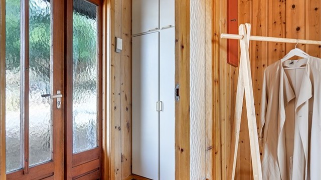 Vindfang med praktisk plassbygget garderobeskap.