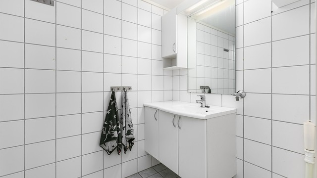 Badet er fra leilighetens byggeår og har gulvvarme. Gulvet og veggene er utført med fliser.