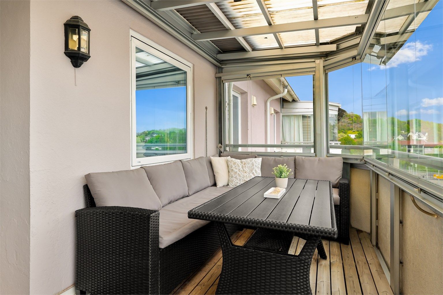 Fra stuen er det utgang til en overbygd og innglasset balkong på 10 kvm. Balkongen er belagt med terrassebord og har rekkverk i glass og metall. Det er montert utebelysning.