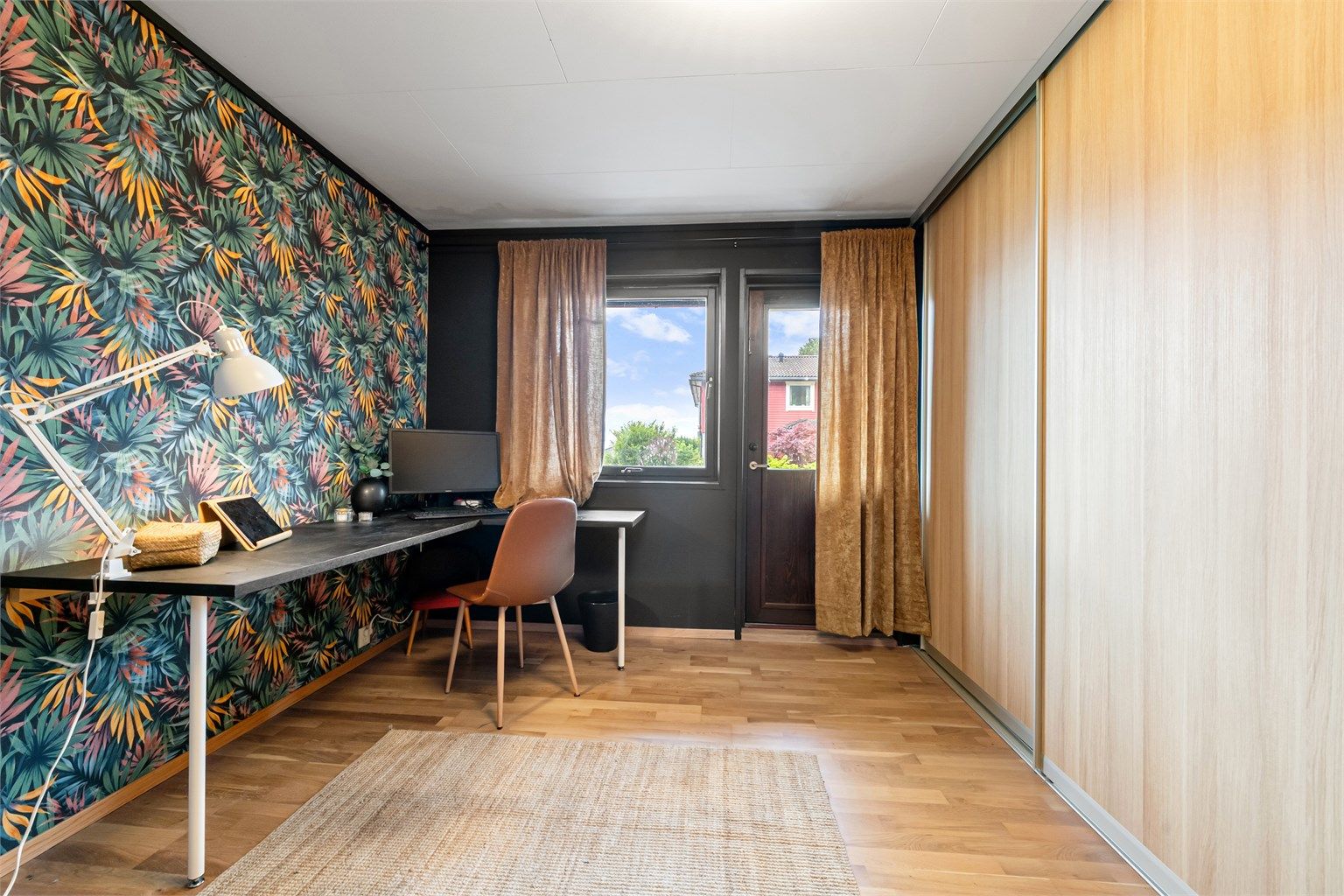 Det andre soverommet i etasjen, her innredet som kontor, har god lagringsplass i skyvedørsgarderobe.