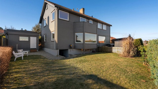 Fin og innholdsrik del av tomannsbolig i Ullandhaugsskråningen, med flott utsikt, solrik tomt med både gressplen og terrasse, carport med bod. ( Foto Arve Gravdal )
Hage med plass til hagemøbler og trampoline. Nedgang til kjeller også fra hage.