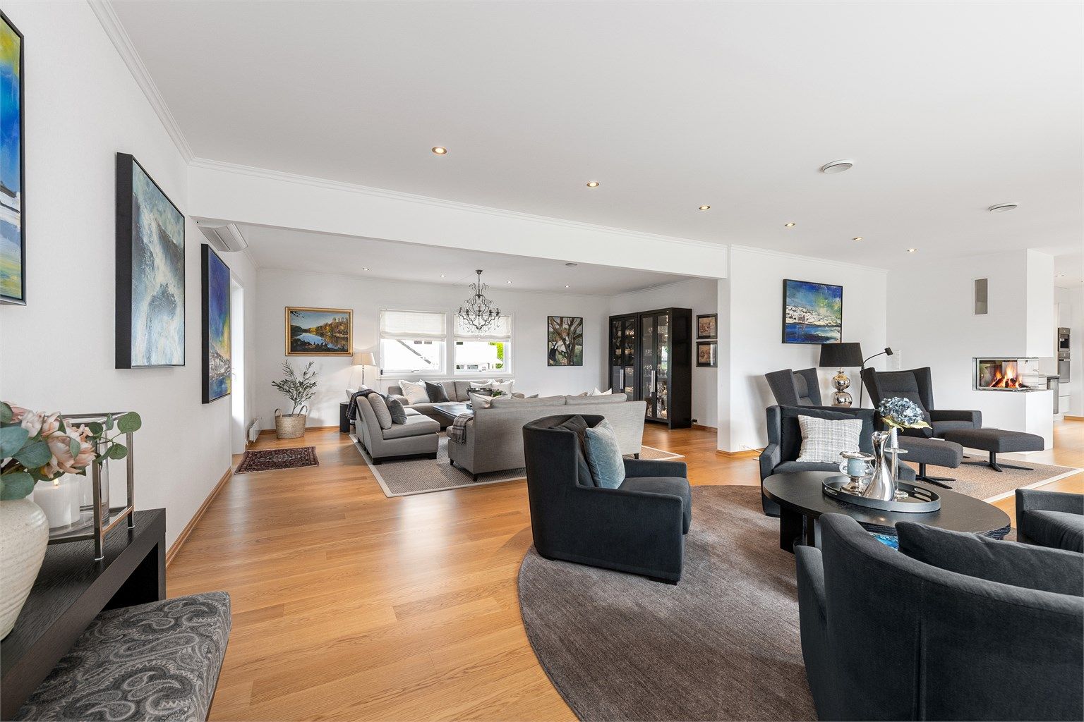 Stuen er delt inn i soner og har en moderne peis med glassinnsats