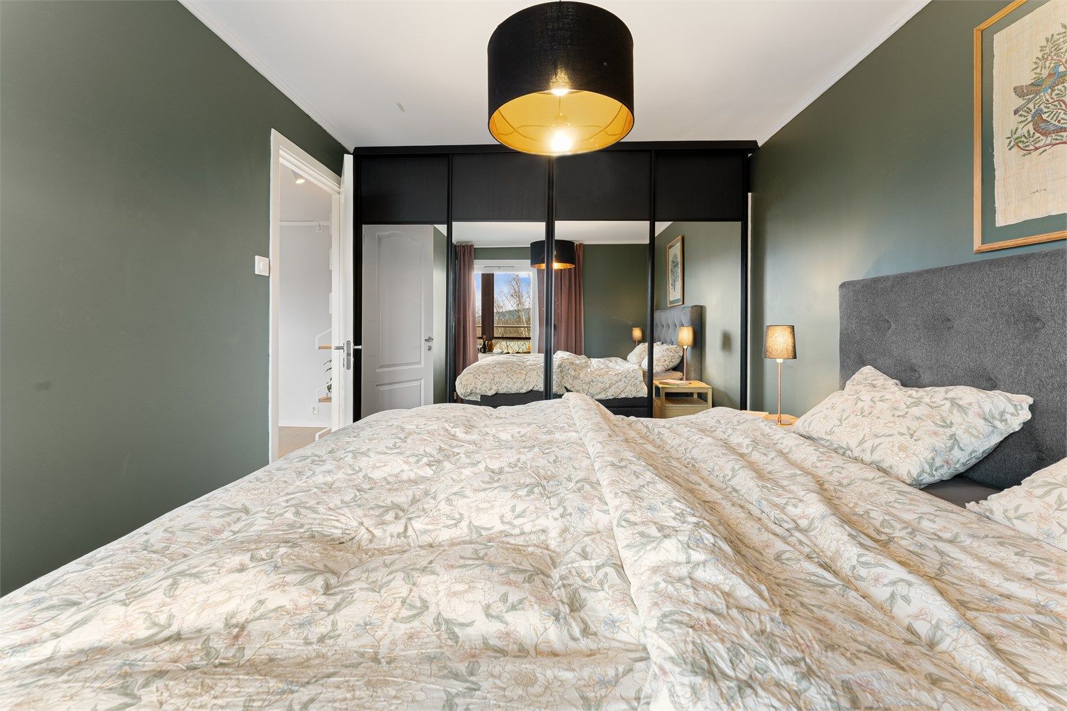 En romslig skyvedørsgarderobe med speilfronter gir rikelig med oppbevaringsplass.