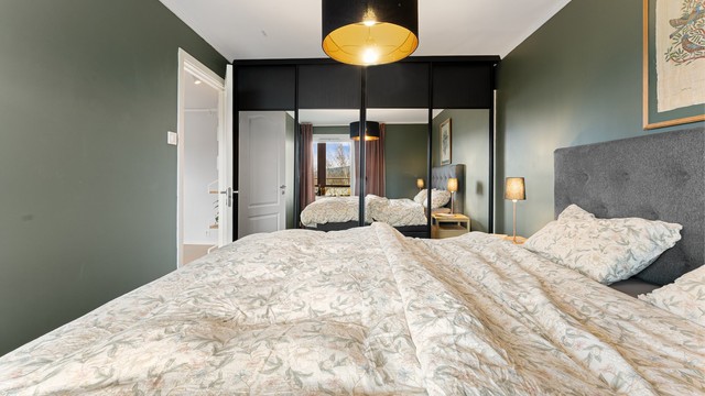 En romslig skyvedørsgarderobe med speilfronter gir rikelig med oppbevaringsplass.