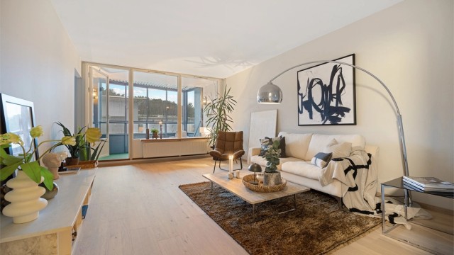 Innglasset balkong i fin forlengelse av stuen. Radiator under vinduene gir god og lun varme