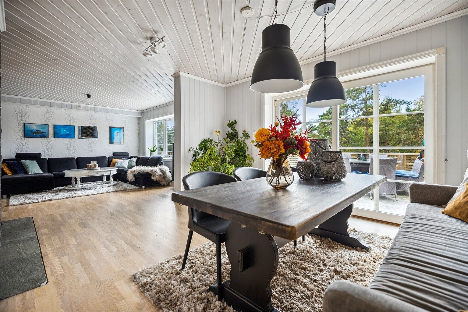 Stuen får godt med naturlig lys fra store vinduer. Hyggelig peisovn gir godt med varme på kalde dager samt en god atmosfære