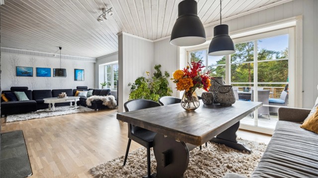 Stuen får godt med naturlig lys fra store vinduer. Hyggelig peisovn gir godt med varme på kalde dager samt en god atmosfære