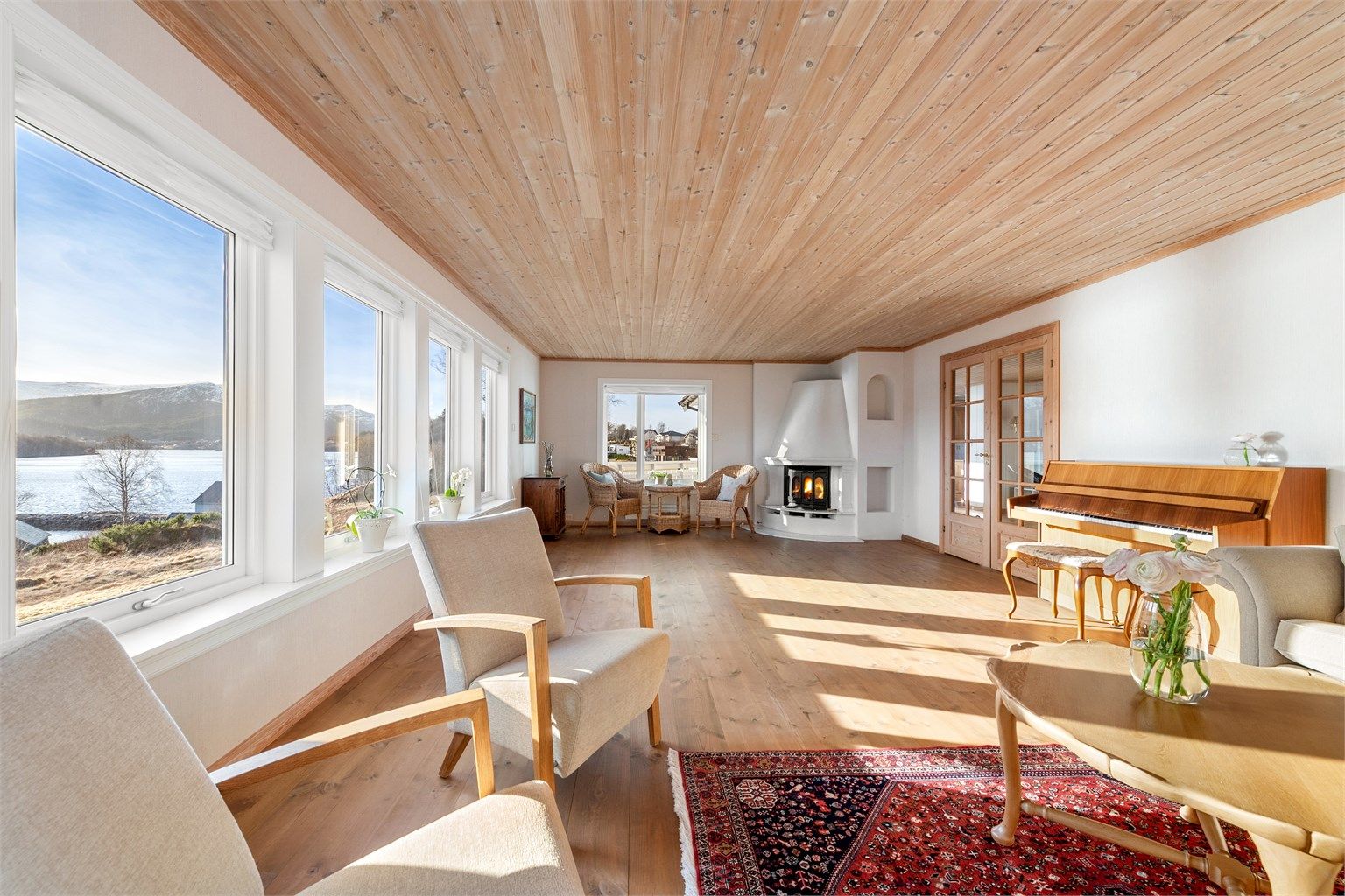 Stor stue med lyse overflater og store vindusflater mot syd og vest som gir godt med lysinnslipp i stuen. 
Murt peis med innsats i stuen