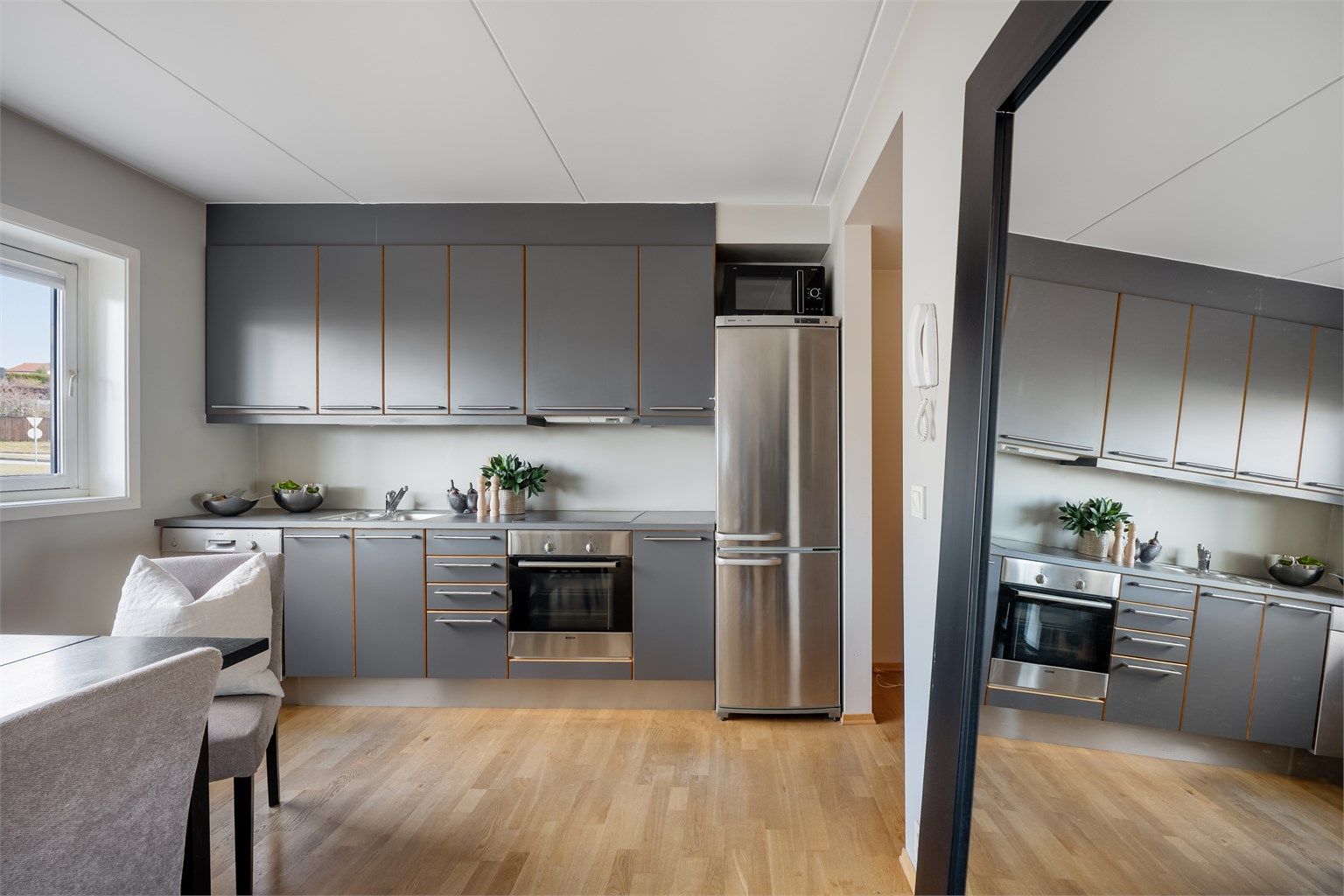 Kjøkkenet er i moderne og fint design med grå fronter og mørk benkeplate.