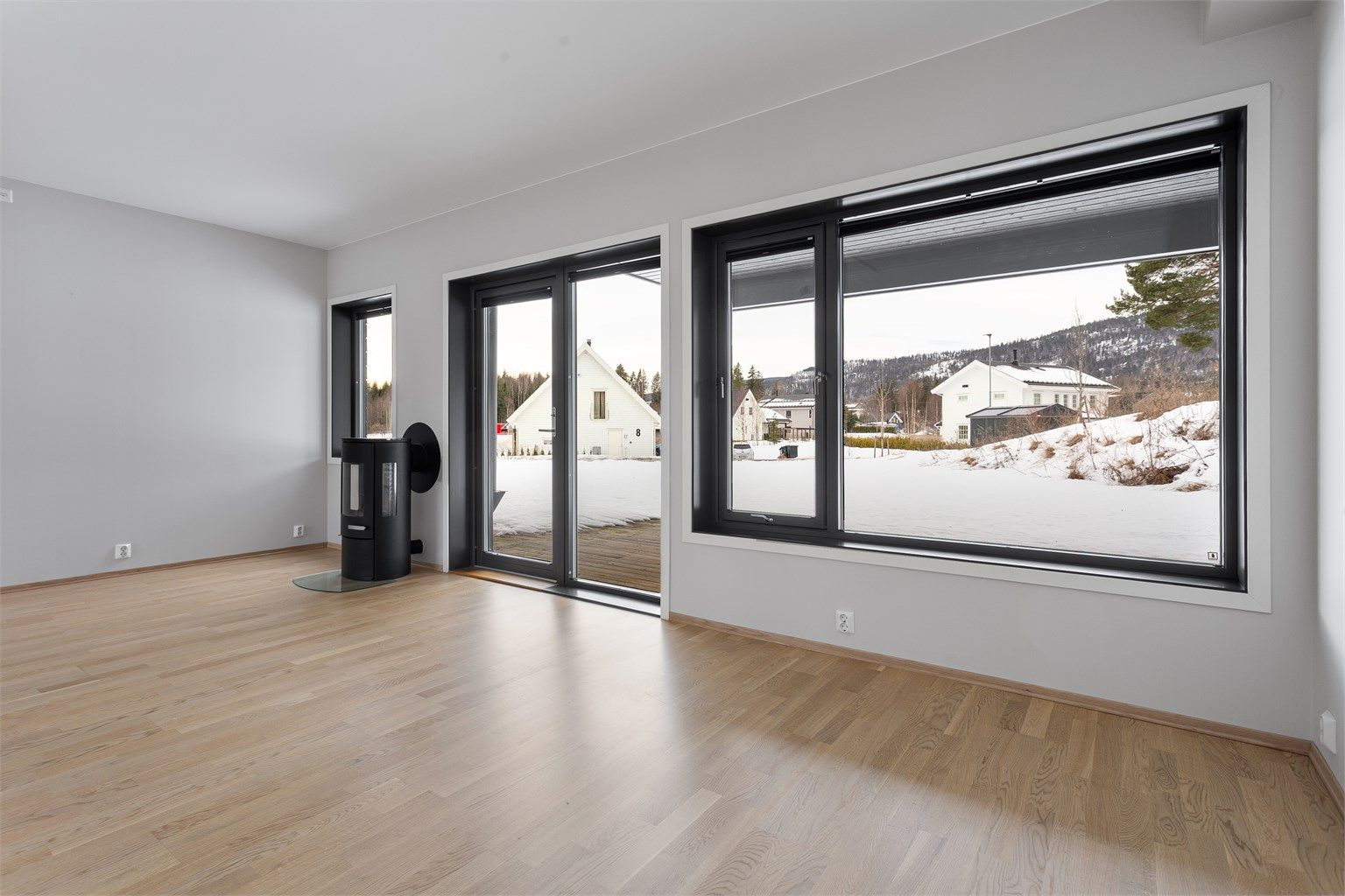 Peisovnen med glassdør gir effektiv tilleggsvarme og en hyggelig atmosfære i stuen.