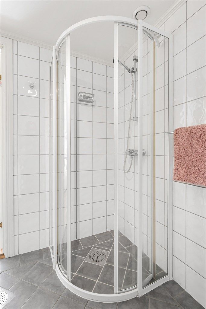Praktisk dusjhjørne med buede dører som sparer plass på baderommet.