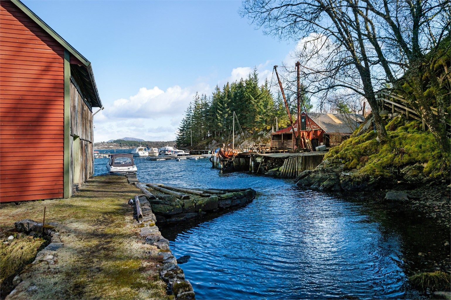 Naust med behov for omfattende rehabilitering. Båtplass i Ådlandsvik Småbåthavn kan kjøpes som et tillegg for kr. 130.000 