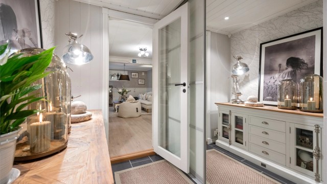 Glassdører skiller gangen fra kjellerstuen og slipper lyset gjennom