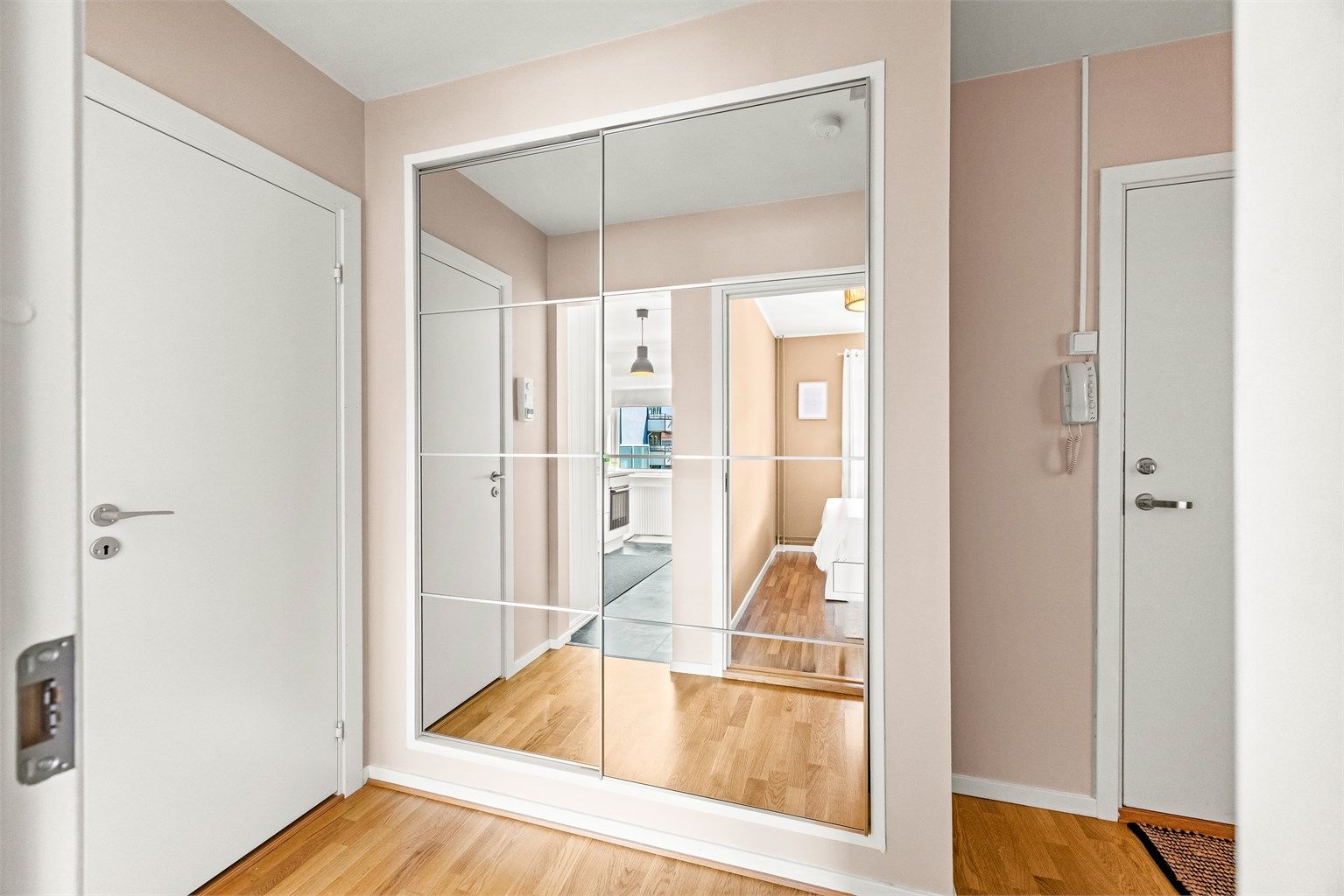Romslig skyvedørsgarderobe med speilfronter gir rikelig med oppbevaringsplass i entréen.