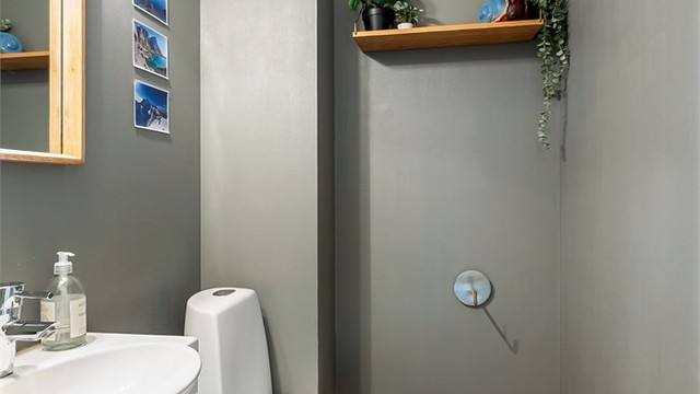 Praktisk toalettrom i første etasje med parkett på gulvet.