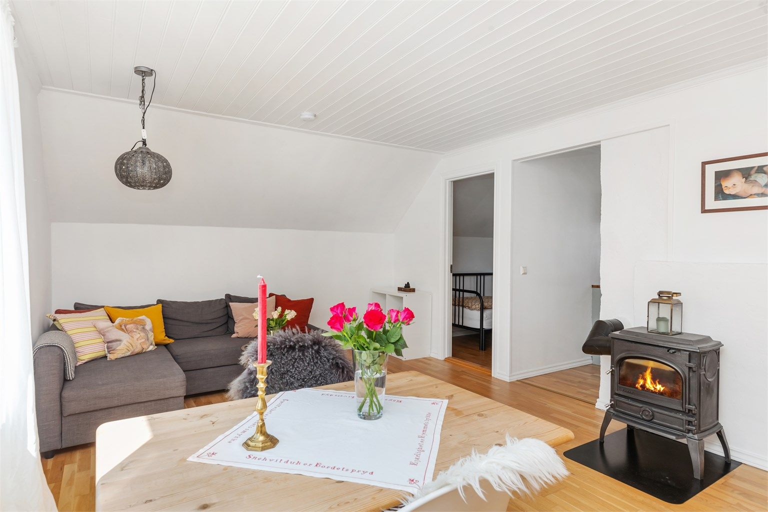 Lys og innbydende stue med vedovn og en varm atmosfære – et naturlig samlingspunkt i hjemmet.