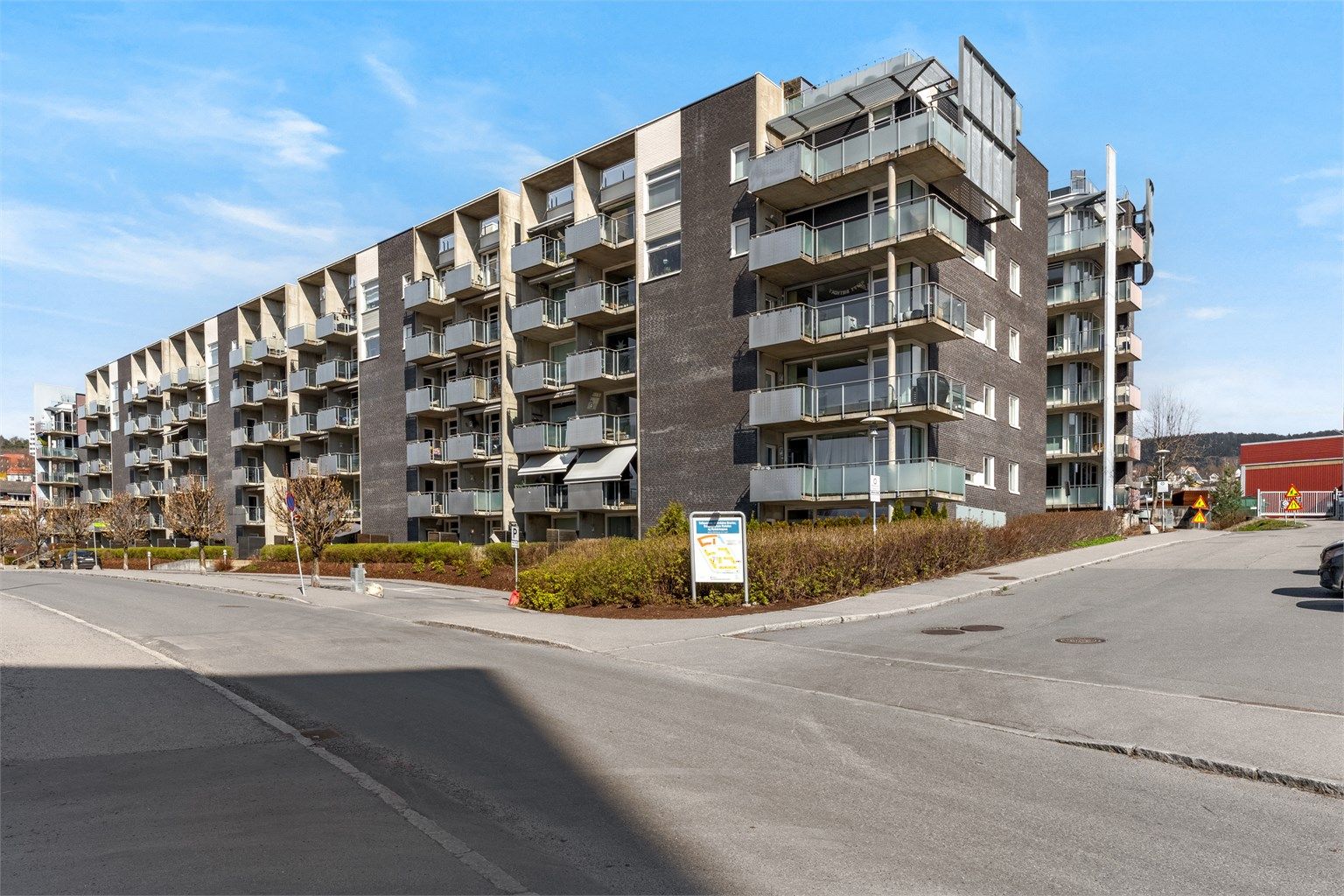 Moderne leilighetsbygg fra 2007 med fasader i teglstein, trekledning og plater.