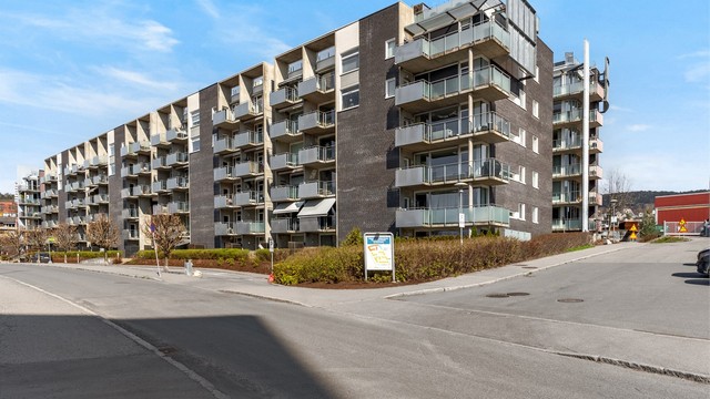 Moderne leilighetsbygg fra 2007 med fasader i teglstein, trekledning og plater.