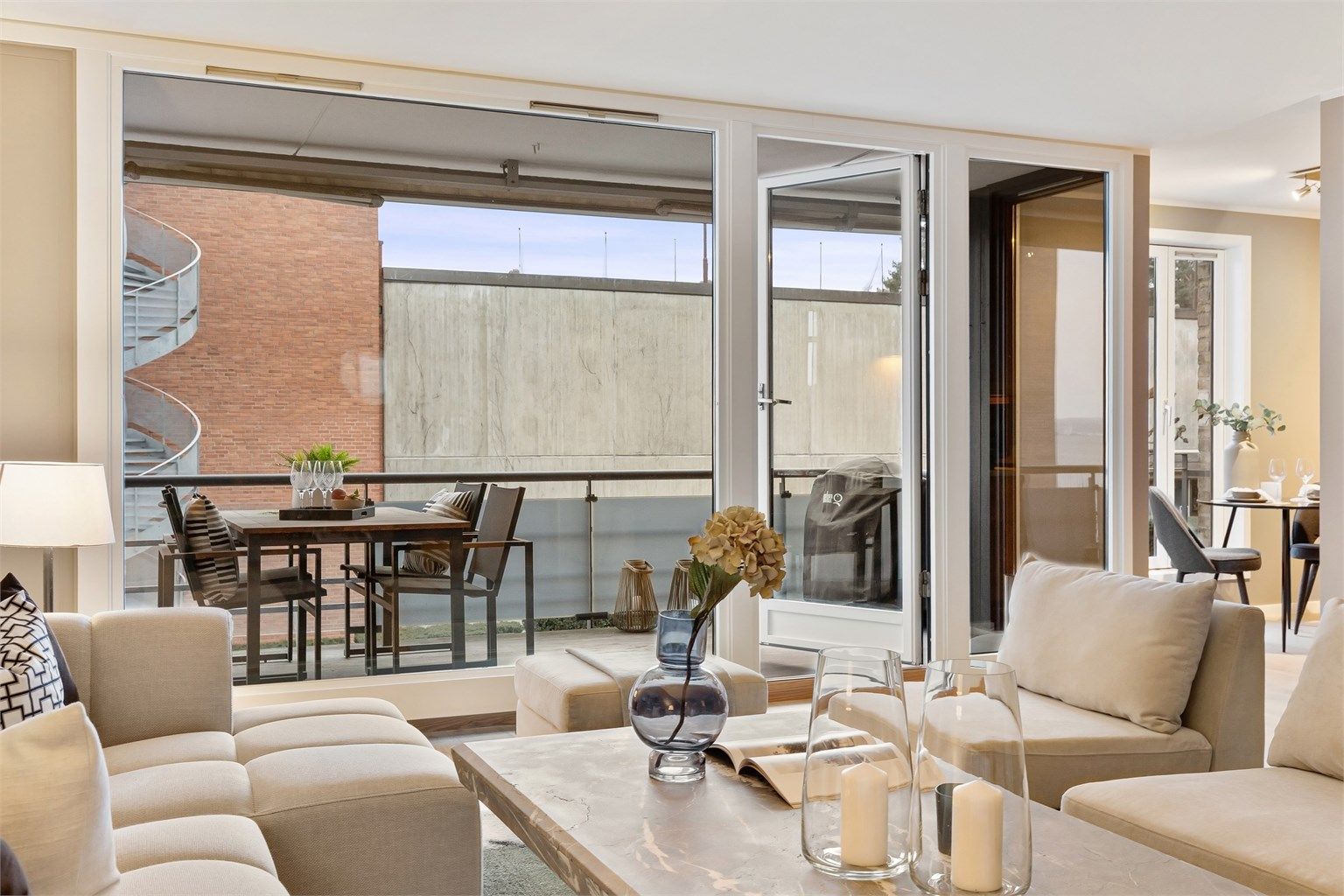 Fra sofakroken har man et fint utsyn mot balkongen og uteområdene.