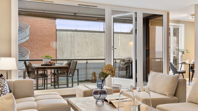 Fra sofakroken har man et fint utsyn mot balkongen og uteområdene.