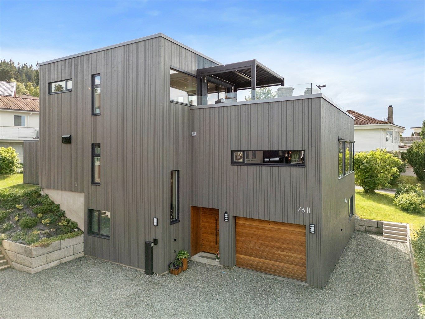 Allerede ved fasaden møter man glimt som synliggjør sans for detaljer, eksempelvis levende spill i treverket og eksklusiv eik på dør/port.