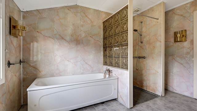 I tillegg til dobbel servant, har badet både badekar og en separat dusjnisje.