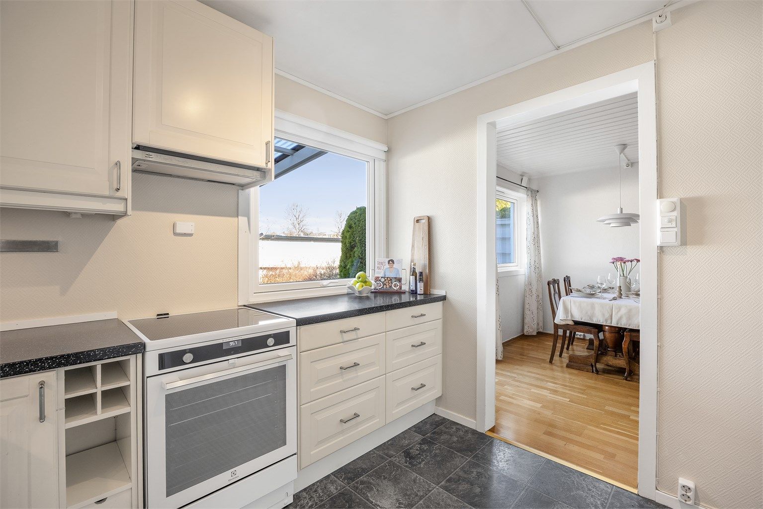 Kjøkkenet har en åpen forbindelse mot spisestuen, som gjør det enkelt å være sosial under matlagingen.