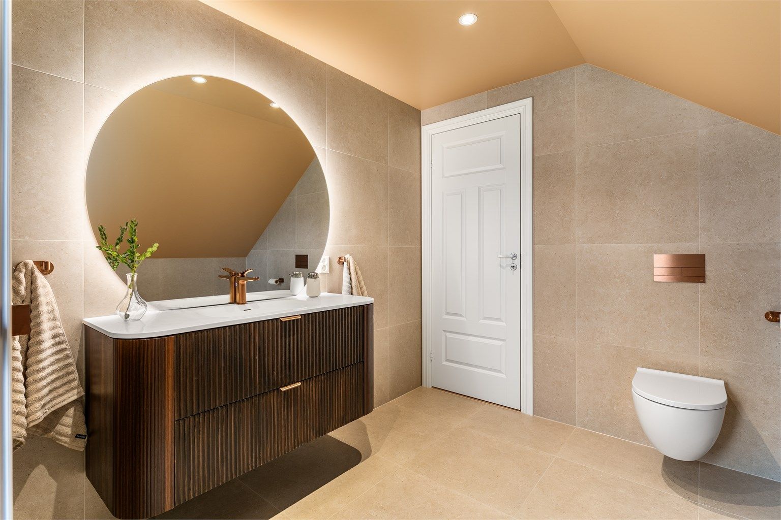 Like fliser, fargevalg og møbler i samme serie skaper helhet og en rød tråd mellom badene. I andre etasje er både blandebatteriene, knagger og trykkplater med mer i kobber.