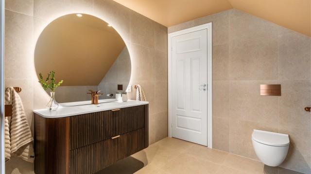 Like fliser, fargevalg og møbler i samme serie skaper helhet og en rød tråd mellom badene. I andre etasje er både blandebatteriene, knagger og trykkplater med mer i kobber.