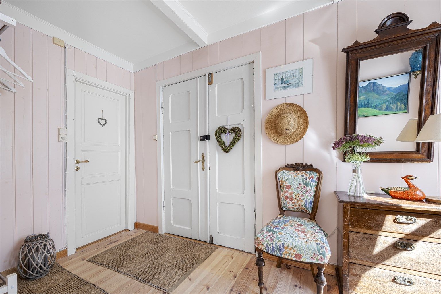 Entréen ønsker velkommen med tregulv og en sjarmerende, tofløyet inngangsdør i tre.