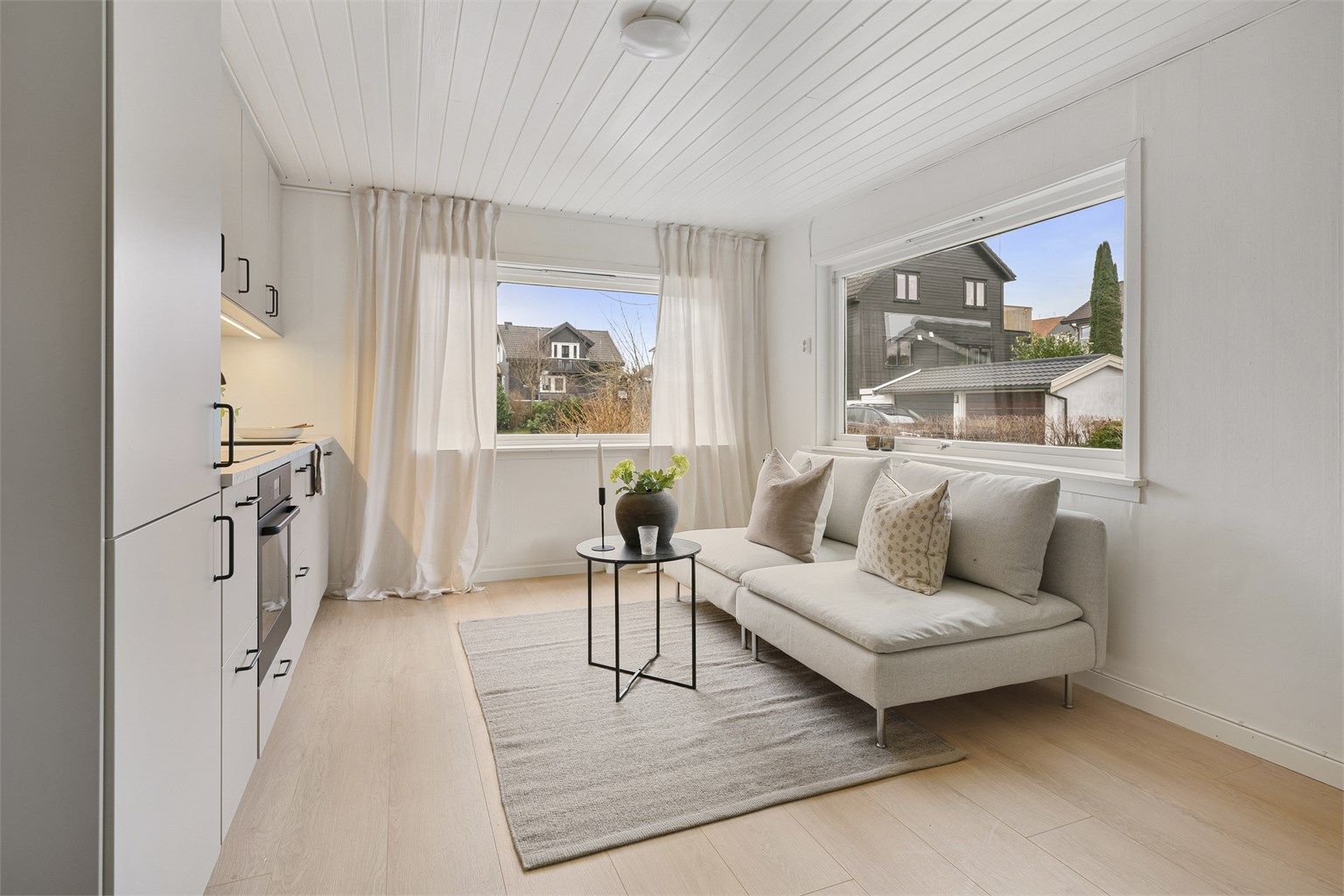 Den åpne løsningen skaper en sosial sone hvor stue og kjøkken glir naturlig over i hverandre.