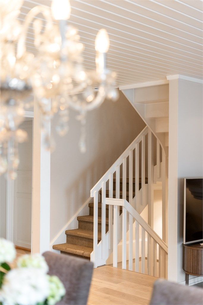 Den malte tretrappen har lukkede opptrinn og er belagt med sisalteppe.