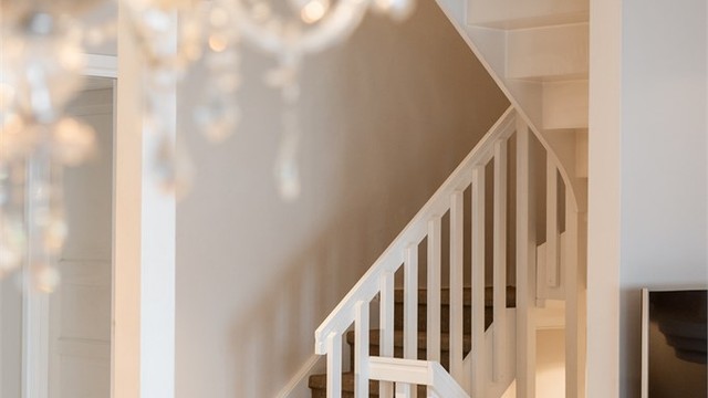 Den malte tretrappen har lukkede opptrinn og er belagt med sisalteppe.