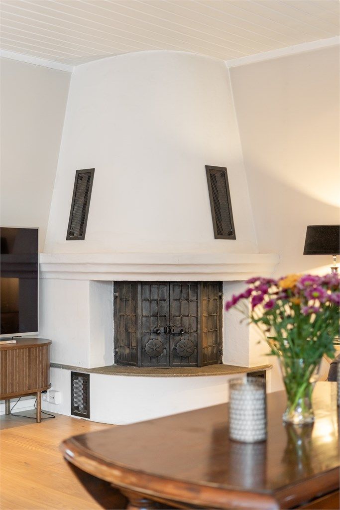 Peisen med innsats i stuen skaper en lun atmosfære på kjølige kvelder.