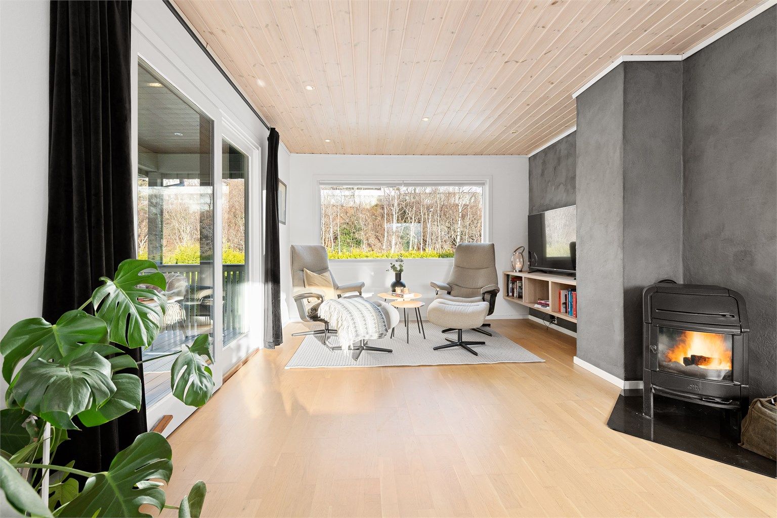 Fra sofagruppen på stuen mot tv-kroken. Skyvedører mot vest til terrasse med trapp til terreng og hage