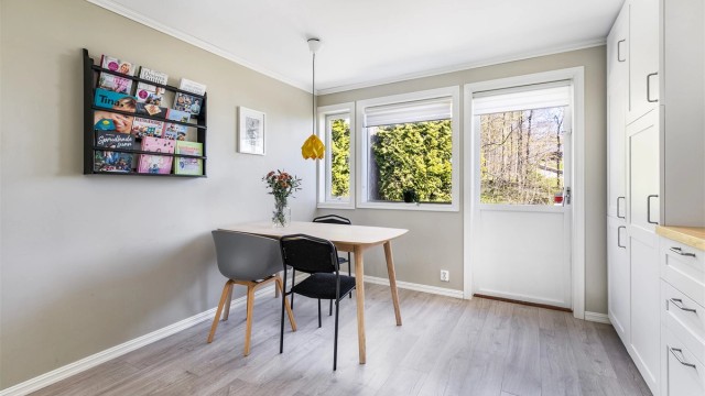 På kjøkkenet er det god plass til et spisebord til hverdagens måltider.
Døren leder ut til bakhagen.