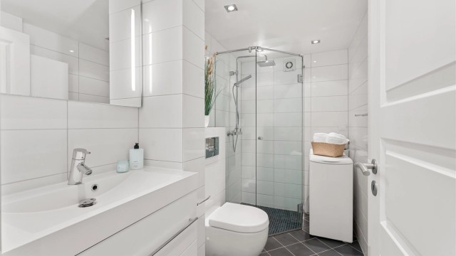 Her er det flislagt gulv med varmekabler, downlights i taket og opplegg for vaskemaskin.