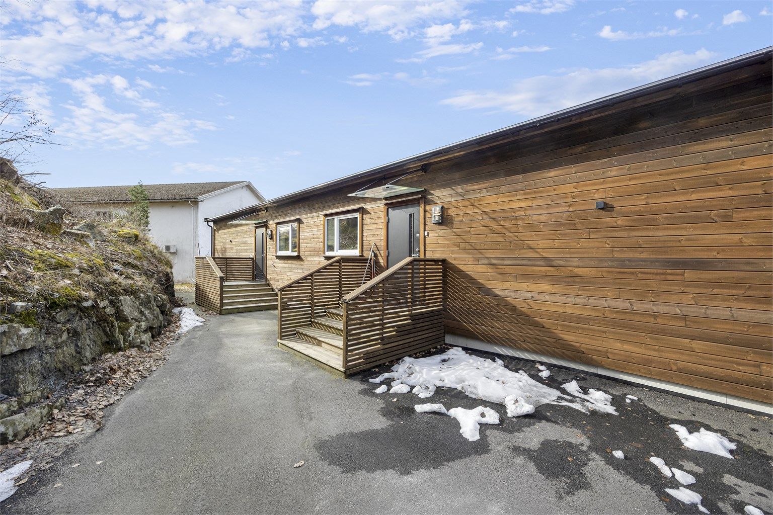 Asfaltert uteområde ved inngangspartiet. Det er kjørevei til døren for av - og pålessing, samt mulighet for etablering av rampe ved behov og etter avklaring i sameiet.