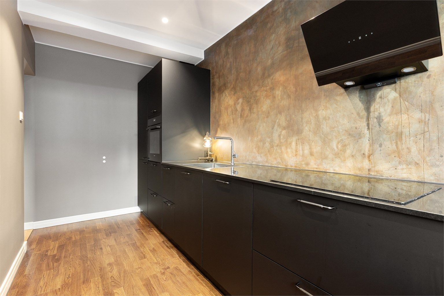 Vegger med behandlet mikrosement over benken gir et unikt og vedlikeholdsvennlig preg. Parkett på gulv og downlights i himling, alt nytt i 2024.