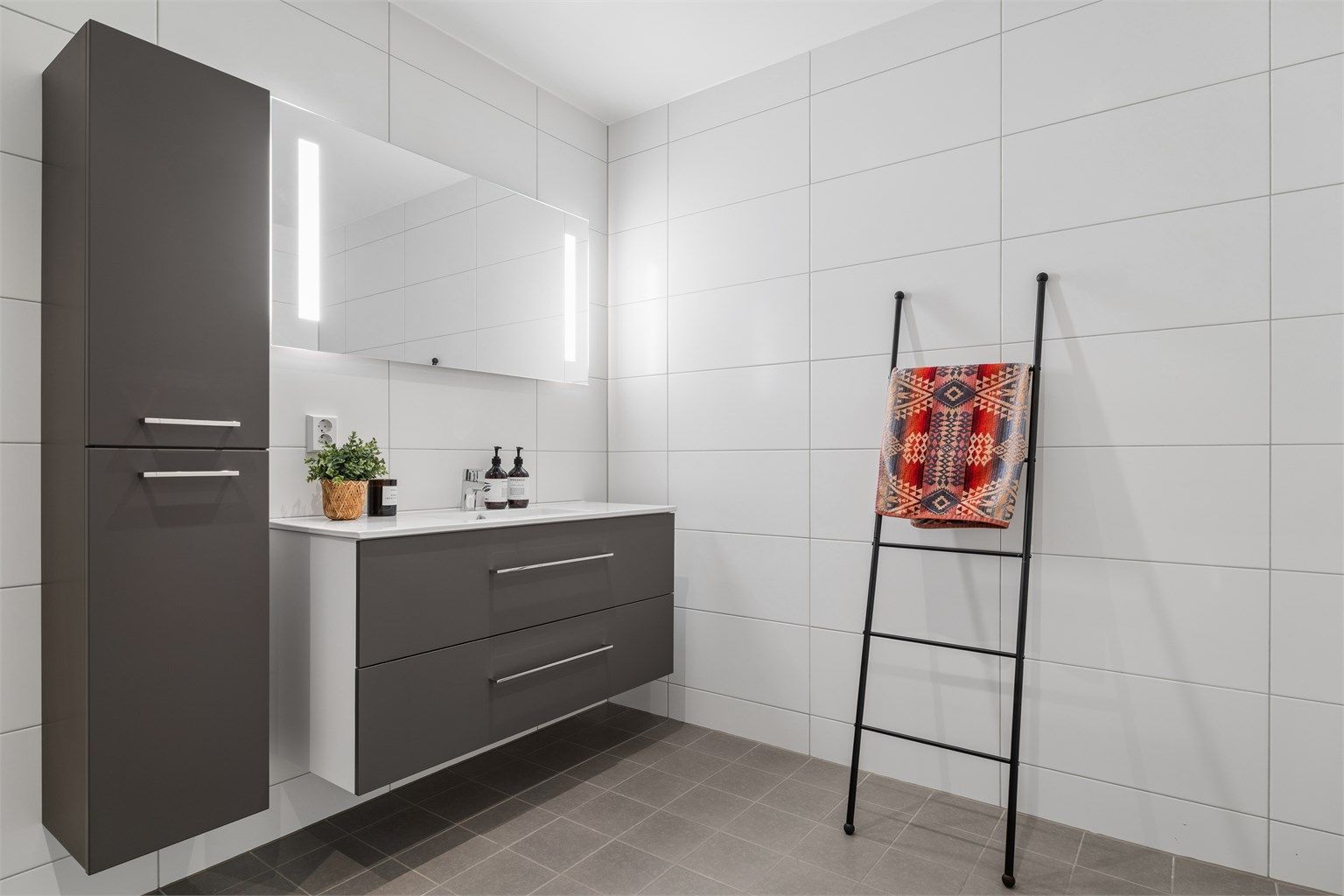 Badet er romslig og har flislagte overflater med gulvvarme.