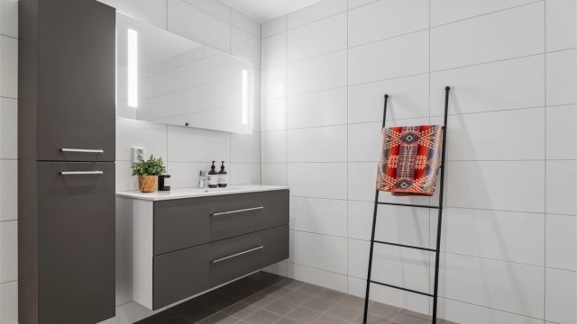 Badet er romslig og har flislagte overflater med gulvvarme.