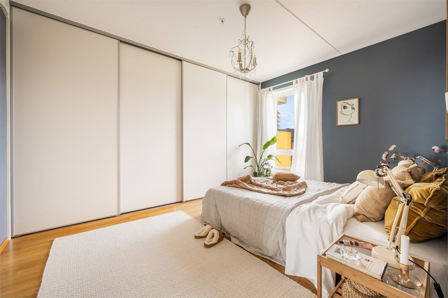 Rommet er innredet med en stor skyvedørsgarderobe med rikelig oppbevaringsplass.