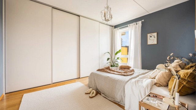 Rommet er innredet med en stor skyvedørsgarderobe med rikelig oppbevaringsplass.