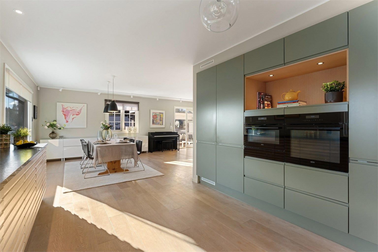 Kjøkkenet er utstyrt med integrerte hvitevarer som kjøleskap, fryseskap, komfyr, mikroovn, oppvaskmaskin og nedfelt platetopp